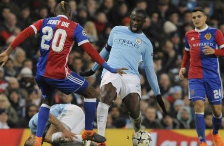 Manchester City's Yaya Toure, center, challenges for the ball with Basel's Geoffroy Serey Die, left, during the Champions League, round of 16, second leg soccer match between Manchester City and Basel at the Etihad Stadium in Manchester, England, Wednesday, March 7, 2018. (AP Photo/Rui Vieira)