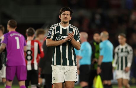 Manchester United's Harry Maguire applauds his teams fans after the end of the English Premier League soccer match between Brentford and Manchester United at the Gtech Community Stadium in London, Saturday, March 30, 2024. The game ended in a 1-1 draw , both goals being scored late into injury time. (AP Photo/Ian Walton)