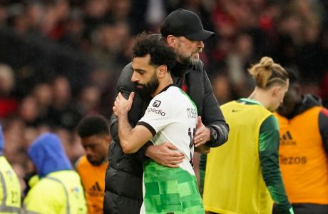 Liverpool's manager Jurgen Klopp hugs substituted Liverpool's Mohamed Salah during the FA Cup quarterfinal soccer match between Manchester United and Liverpool at the Old Trafford stadium in Manchester, England, Sunday, March 17, 2024. (AP Photo/Dave Thompson)