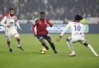Lille's Jonathan Bamba, center, challenges for the ball with Lyon's Nabil Fekir, left, and Bertrand Traore, right, during a French League One soccer match in Decines, near Lyon, central France, Sunday, May 5, 2019. (AP Photo/Laurent Cipriani)