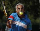 Mansour Bahrami of Iran returns the ball in an exhibition match holding 7 tennis balls in his left hand and one in his mouth at the French Open tennis tournament in Roland Garros stadium in Paris, Saturday June 4, 2011. (AP Photo/Michel Spingler)