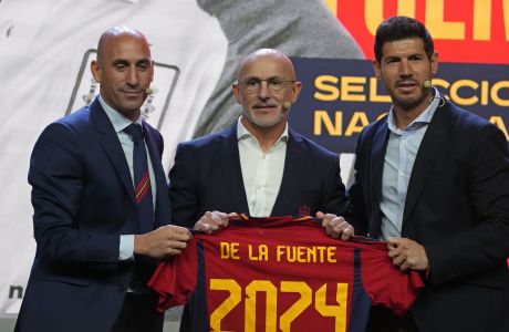 Luis de la Fuente, centre, holds up a shirt with his name alongside the president of the Spanish Football federation, Luis Rubiales, left and new Sports Director José Francisco Molina during his presentation as Spain's new soccer coach in Las Rozas, just outside of Madrid, Spain, Monday, Dec. 12, 2022. Luis de la Fuente replaces Luis Enrique after the national team was eliminated in the round of 16 at the World Cup. (AP Photo/Paul White)