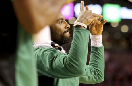 Boston Celtics' Kyrie Irving (11) celebrates a 3-point shot from the bench during the second half of an NBA basketball game against the Sacramento Kings in Boston, Wednesday, Nov. 1, 2017. (AP Photo/Mary Schwalm)