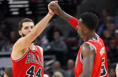 Chicago Bulls' Nikola Mirotic (44) and Bobby Portis celebrate the team's lead late in the second half of an NBA basketball game against the Boston Celtics, Monday, Dec. 11, 2017, in Chicago. (AP Photo/Charles Rex Arbogast)