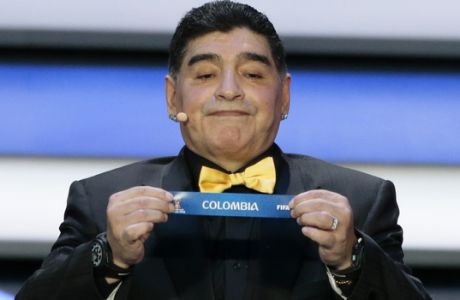 Argentine soccer legend Diego Maradona holds up the team name of Colombia at the 2018 soccer World Cup draw in the Kremlin in Moscow, Friday, Dec. 1, 2017. (AP Photo/Ivan Sekretarev)