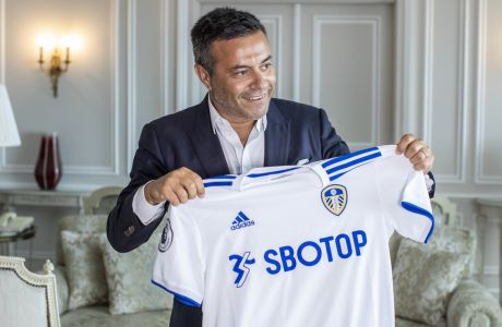 In this photo taken on Wednesday, Aug. 19, 2020, Leeds owner Andrea Radrizzani holds a Leeds  shirt, during an interview with the Associated Press in Lisbon, Portugal. Leeds is counting on Marcelo Bielsa leading the team in the Premier League while planning for a future without the enigmatic manager. In his second season in charge, the Argentine ended the teams 16-year exile from the worlds richest league by gaining promotion as Championship winners before his contract expired last month. (AP Photo/Manu Fernandez)