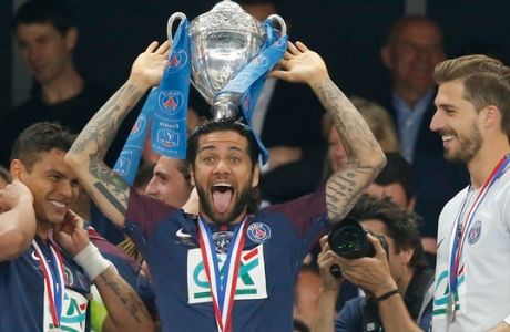 PSG's Dani Alves, left, holds the trophy a he jokes while his teammate goalkeeper Kevin Trapp looks on during the French Cup soccer final between Les Herbiers and Paris Saint Germain at the Stade de France stadium in Saint-Denis, outside Paris, Tuesday, May 8, 2018. (AP Photo/Michel Euler)
