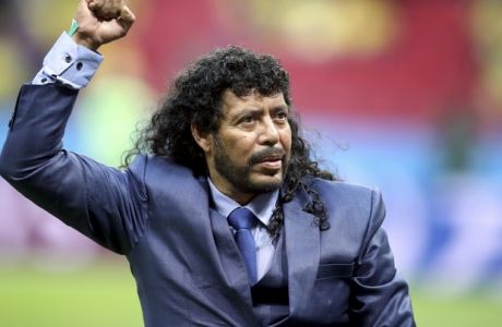 Rene Higuita, former goalkeeper of the national team of Colombia, raises a fist prior to the group H match between Poland and Colombia at the 2018 soccer World Cup at the Kazan Arena in Kazan, Russia, Sunday, June 24, 2018. (AP Photo/Thanassis Stavrakis)
