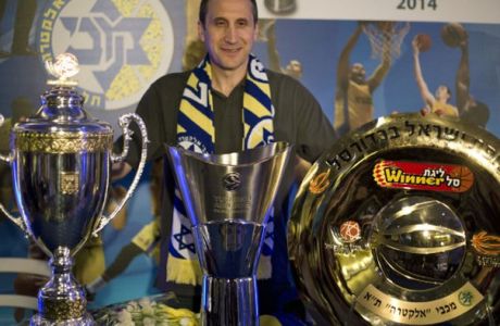 FILE - In this June 12, 2014, file photo, Maccabi Tel Aviv's head coach David Blatt poses for photographers with the Israeli cup, European club champions cup and the Israeli club champions trophy after a news conference in Tel Aviv, Israel. The Cleveland Cavaliers offered the successful European coach its coaching job Thursday night, June 19,2 014, and is discussing a contract with him, said a person who spoke to The Associated Press on condition of anonymity because the team is not commenting. (AP Photo/Ariel Schalit, File)