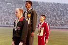 Ο Αμπέμπε Μπικίλα (κέντρο), ο Μπάζιλ Χίτλι (αριστερά) και ο Κοκίτσι Τσουμπουράγια (δεξιά) κατά την απονομή μεταλλίων στον μαραθώνιο των Ολυμπιακών Αγώνων 1964 στο Τόκιο, Τετάρτη 21 Οκτωβρίου 1964