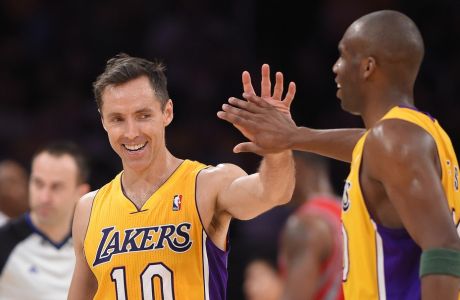 Los Angeles Lakers' Steve Nash, left, is congratulated by guard Jodie Meeks after Nash's assist to tie for third place in NBA career assists, during the first half of an NBA basketball game against the Houston Rockets, Tuesday, April 8, 2014, in Los Angeles. Meeks scored on the play. (AP Photo/Mark J. Terrill) 