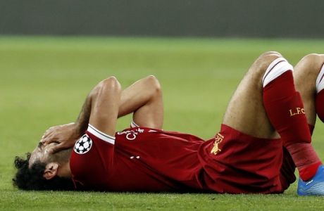 Liverpool's Mohamed Salah grimaces on the ground after injuring himself during the Champions League Final soccer match between Real Madrid and Liverpool at the Olimpiyskiy Stadium in Kiev, Ukraine, Saturday, May 26, 2018. (AP Photo/Pavel Golovkin)