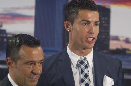 FILE - In this Friday Oct. 2, 2015 file photo, Real Madrid's striker Cristiano Ronaldo, right, poses with his agent Jorge Mendes after being given a silver boot award during a ceremony at the Santiago Bernabeu stadium in Madrid, Spain. Wolverhampton Wanderers sealed a return to the Premier League on Sunday, April 15, 2018 after a six-year absence in a promotion push that has been funded in China, masterminded in Portugal and realized in an industrial city in central England. Their route back to the Premier League isnt without controversy owing to the clubs close links to super-agent Jorge Mendes, whose seven clients at Wolves include their star player and manager. (AP Photo/Paul White, file)