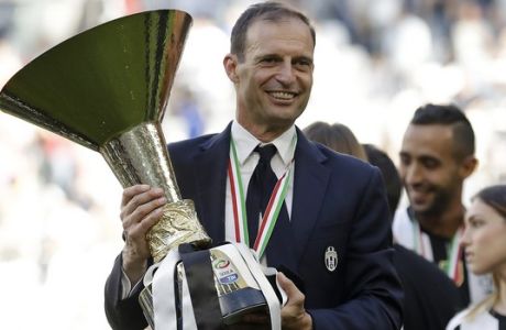 FILE - In this Sunday, May 21, 2017 filer, Juventus coach Massimiliano Allegri holds the trophy as Juventus players celebrate winning an unprecedented sixth consecutive Italian title, at the end of the Serie A soccer match between Juventus and Crotone at the Juventus stadium, in Turin, Italy. Juventus will face Real Madrid in the Champions League final in Cardiff, Wales, on Saturday, June 3, 2017. (AP Photo/Antonio Calanni, File)