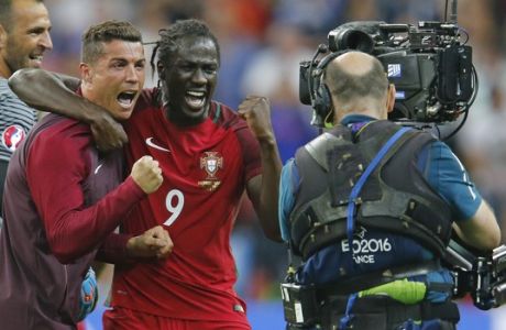 Portugal's Cristiano Ronaldo, left, and Eder celebrate at the end of the Euro 2016 final soccer match between Portugal and France at the Stade de France in Saint-Denis, north of Paris, Sunday, July 10, 2016. Portugal won the match 1-0. (AP Photo/Michael Probst)