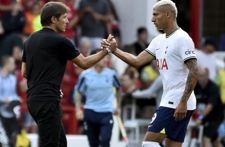 Tottenham's head coach Antonio Conte, left, shakes hands with Tottenham's Richarlison after his team won the English Premier League soccer match between Nottingham Forest and Tottenham Hotspur at the City Ground stadium in Nottingham, England, Sunday, Aug. 28, 2022.(AP Photo/Rui Vieira)
