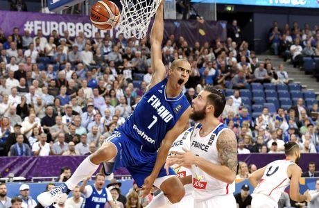 Shawn Huff of Finland hangs from the rim after Finland's two-point basket with Joffrey Lauvergne of France, centre right, during their Eurobasket European Basketball Championship  match in Helsinki, Thursday Aug. 31. 2017. (Juss Nukari/Lehtikuva via AP)