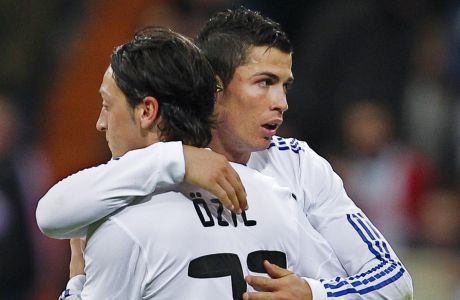 Real Madrid's Cristiano Ronaldo from Portugal, right, hugs teammate Mesut Ozil from Germany after scoring against Valencia during their La Liga soccer match at the Santiago Bernabeu stadium in Madrid Saturday, Dec. 4, 2010.  (AP Photo/Victor R. Caivano)