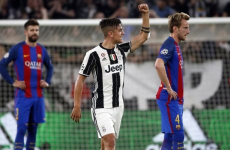Juventus's Paulo Dybala, center, celebrates next to Barcelona's Ivan Rakitic, right, and Gerard Pique after scoring his side's second goal during a Champions League, quarterfinal, first-leg soccer match between Juventus and Barcelona, at the Juventus Stadium in Turin, Italy, Tuesday, April 11, 2017. (AP Photo/Antonio Calanni)