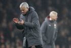 Manchester United coach Jose Mourinho applauds while Arsenal's manager Arsene Wenger looks on in the background during the English Premier League soccer match between Arsenal and Manchester United at the Emirates stadium in London, Saturday, Dec. 2, 2017. (AP Photo/Kirsty Wigglesworth)