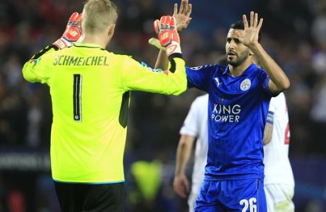 Leicester goalkeeper Kasper Schmeichel, left, and Leicester's Riyad Mahrez celebrate after the Champions League round of 16 soccer match between Sevilla and Leicester City at the Ramon Sanchez-Pizjuan stadium in Seville, Spain, Wednesday, Feb. 22, 2017. Sevilla won the match 2-1. (AP Photo/Miguel Morenatti)