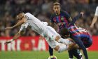 Real Madrid's Karim Benzema falls as he is tackled by Barcelona's Andreas Christensen, right, during the Spanish La Liga soccer match between Barcelona and Real Madrid at Camp Nou stadium in Barcelona, Spain, Sunday, March 19, 2023. (AP Photo/Joan Mateu)