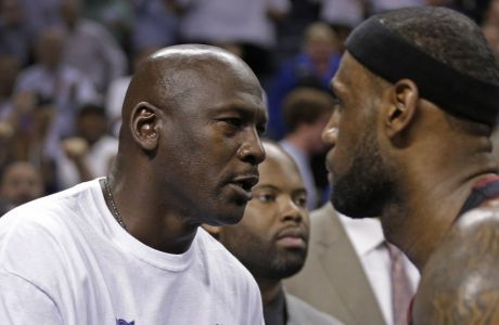 Charlotte Bobcats owner Michael Jordan, left, shakes hands with Miami Heat's LeBron James, right, after Game 4 of an opening-round NBA basketball playoff series in Charlotte, N.C., Monday, April 28, 2014. The Heat won 109-98, sweeping the series. (AP Photo/Chuck Burton)