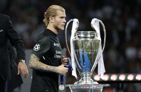 Liverpool goalkeeper Loris Karius walks past the trophy after the Champions League Final soccer match between Real Madrid and Liverpool at the Olimpiyskiy Stadium in Kiev, Ukraine, Saturday, May 26, 2018. Real Madrid won 3-1. (AP Photo/Pavel Golovkin)
