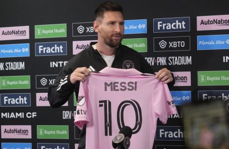 Inter Miami's Lionel Messi holds up his team jersey during a soccer news conference, Thursday, Aug. 17, 2023, in Fort Lauderdale, Fla. (AP Photo/Marta Lavandier)