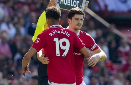 Manchester United's Harry Maguire, right, walks in as substitute for Manchester United's Raphael Varane during the English Premier League soccer match between Manchester United and Wolverhampton at the Old Trafford stadium in Manchester, England, Saturday, May 13, 2023. (AP Photo/Jon Super)
