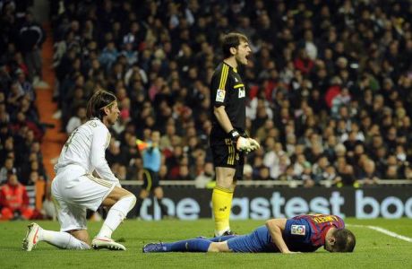 Real Madrid's goalkeeper and captain Iker Casillas (C), Real Madrid's defender Sergio Ramos (L) and Barcelona's midfielder Andres Iniesta (R) react during the Spanish Cup "El clasico" football match Real Madrid vs Barcelona at the Santiago Barnabeu stadium in Madrid on January 18, 2012.   AFP PHOTO/ PEDRO ARMESTRE (Photo credit should read PEDRO ARMESTRE/AFP/Getty Images)