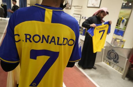 A man wears Cristiano Ronaldo jerseys at Al Nassr soccer club store in Riyadh, Saudi Arabia, Monday, Jan 2, 2023. Ronaldo completed a lucrative move to Saudi Arabian club Al Nassr on Friday in a deal that is a landmark moment for Middle Eastern soccer but will see one of Europe's biggest stars disappear from the sport's elite stage. (AP Photo/Amr Nabil)