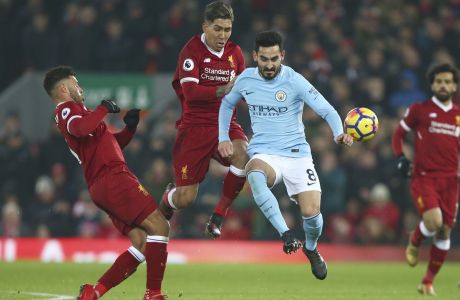 Liverpool's Alex Oxlade-Chamberlain, left, Liverpool's Roberto Firmino, second left, and Manchester City's Ilkay Gundogan, second right, vie for the ball during the English Premier League soccer match between Liverpool and Manchester City at Anfield Stadium, in Liverpool, England, Sunday Jan. 14, 2018. (AP Photo/Dave Thompson)