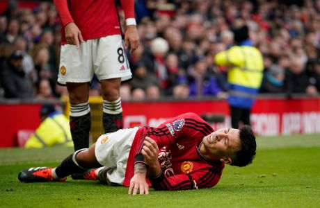 Manchester United's Lisandro Martinez grimaces in pain after an injury during the English Premier League soccer match between Manchester United and West Ham United at the Old Trafford stadium in Manchester, England, Sunday, Feb. 4, 2024. (AP Photo/Dave Thompson)