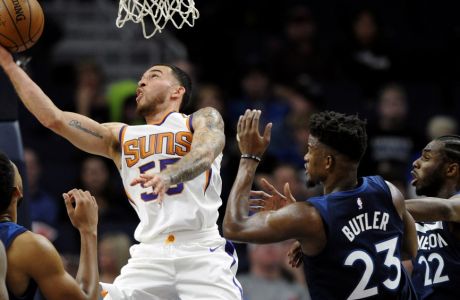 Phoenix Suns' Mike James (55) shoots against center Minnesota Timberwolves' Jimmy Butler (23) and Andrew Wiggins (22) during the fourth quarter of an NBA basketball game on Sunday, Nov. 26, 2017, in Minneapolis. The Timberwolves won 119-108. (AP Photo/Hannah Foslien)