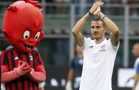 FILE - In this photo taken on Aug. 3, 2017, former Juventus player Leonardo Bonucci waves to his new fans, prior to the start of an Europa League third qualifying round, second leg, soccer match at the San Siro stadium in Milan, Italy. After a tumultuous two months, and in spite of loosing one of its key defenders who was sold to AC Milan, Juventus is looking to get back to what it does best: winning trophies. (AP Photo/Antonio Calanni)