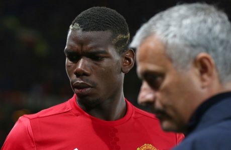 FILE - In this Thursday, Sept. 29, 2016 file photo Manchester United's manager Jose Mourinho, right, with Manchester United's Paul Pogba just prior to the start of Europa League group A soccer match between Manchester United and Zorya Luhansk at Old Trafford, Manchester, England. Manchester United says Jose Mourinho has left the Premier League club with immediate effect. The decision was announced Tuesday Dec.18, 2018, two days after a 3-1 loss to Liverpool left United 19 points off the top of the Premier League after 17 games. (AP Photo/Dave Thompson, File)