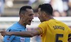 Referee Jose Maria Sanchez Martinez, left, discusses with Barcelona's Sergio Busquets during a Spanish La Liga soccer match between Barcelona and Atletico Madrid, at the Camp Nou stadium in Barcelona, Spain, Sunday, April 23, 2023. (AP Photo/Joan Mateu)