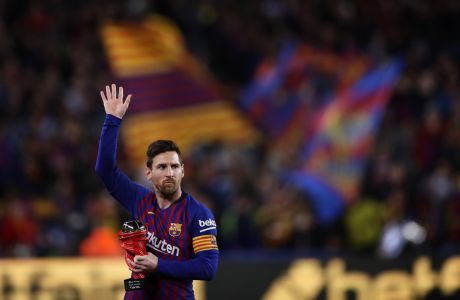 FILE - In this Saturday, April 6, 2019 file photo, Barcelona forward Lionel Messi waves at the crowd as he holds the trophy of the best Spanish La Liga player prior to a soccer match between FC Barcelona and Atletico Madrid at the Camp Nou stadium in Barcelona, Spain. Barcelona says Lionel Messi will not stay with the club, it was reported on Aug. 5, 2021 in a statement that a deal between the club and the player had been reached but financial obstacles made it impossible for the player to remain with the club.  (AP Photo/Manu Fernandez, File)