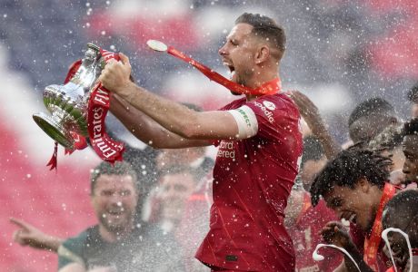 Liverpool's Jordan Henderson celebrates with the trophy at the end of the English FA Cup final soccer match between Chelsea and Liverpool, at Wembley stadium, in London, Saturday, May 14, 2022. (AP Photo/Kirsty Wigglesworth)