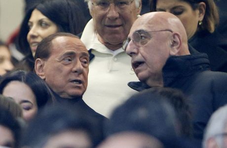 FILE - In this  Jan. 31, 2016 file photo, AC Milan president Silvio Berlusconi, left, is flanked by vice president Adriano Galliani during a Serie A soccer match between AC Milan and Inter Milan, at the San Siro stadium in Milan, Italy. The sale of AC Milan to a group of Chinese investors was again delayed on Friday, March 3, 2017. (AP Photo/Luca Bruno)