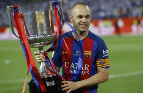 Barcelona's captain Andres Iniesta poses with the trophy after the Copa del Rey final soccer match between Barcelona and Alaves at the Vicente Calderon stadium in Madrid, Spain, Saturday, May 27, 2017. Barcelona won the match 3-1. (AP Photo/Francisco Seco)
