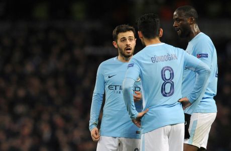 Manchester City's Bernardo Silva, left, speaks with Ilkay Gundogan, center, and Yaya Toure during the Champions League, round of 16, second leg soccer match between Manchester City and Basel at the Etihad Stadium in Manchester, England, Wednesday, March 7, 2018. (AP Photo/Rui Vieira)