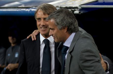 Manchester City's coach Roberto Mancini of Italy is embraced by Real Madrid coach Jose Mourinho from Portugal before a Champions League Group D soccer match at the Santiago Bernabeu Stadium, in Madrid, Tuesday, Sept. 18, 2012. (AP Photo/Daniel Ochoa De Olza)
