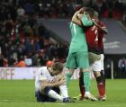 Tottenham's Harry Kane sits on the pitch with an injury as Manchester United players hugs teammate and goalkeeper David de Gea, left in green, after the English Premier League soccer match between Tottenham Hotspur and Manchester United at Wembley stadium in London, England, Sunday, Jan. 13, 2019. (AP Photo/Matt Dunham)