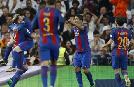 Barcelona's Ivan Rakitic, left, celebrates with his teammate Lionel Messi, Luis Suarez, and Sergi Roberto, right, after scoring during a Spanish La Liga soccer match between Real Madrid and Barcelona, dubbed 'el clasico', at the Santiago Bernabeu stadium in Madrid, Spain, Sunday, April 23, 2017. (AP Photo/Francisco Seco)