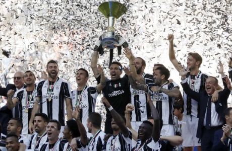 Juventus goalkeeper Gianluigi Buffon lifts the trophy as Juventus players celebrate winning an unprecedented sixth consecutive Italian title, at the end of the Serie A soccer match between Juventus and Crotone at the Juventus stadium, in Turin, Italy, Sunday, May 21, 2017. (AP Photo/Antonio Calanni)