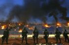 Policemen stand guard as fires burn in the stands after a Serbian first division soccer match between Partizan and Red Star in Belgrade April 8, 2009. REUTERS/Marko Djurica (SERBIA CONFLICT DISASTER SPORT SOCCER IMAGE OF THE DAY TOP PICTURE)