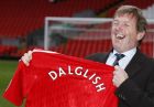 Liverpool's new manager Kenny Dalglish poses for the media in front of The Kop at Anfield stadium in Liverpool, England, Monday Jan. 10, 2011, as he begins his first proper week in charge having only been handed the job after Roy Hodgson's departure was confirmed on Jan. 8.(AP Photo/Tim Hales)