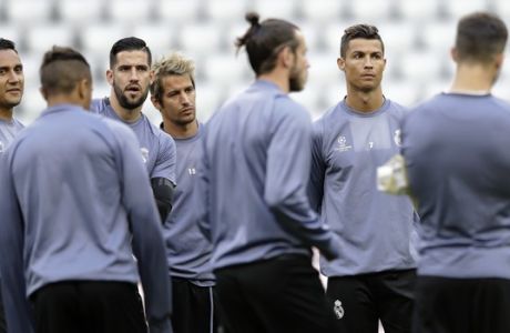 Real Madrid's Cristiano Ronaldo, 2nd right, goalkeeper Kiko Casilla, 3rd left, and Fabio Coentrao, center, gather with team mates for a training session prior to the Champions League quarterfinal first leg soccer match between FC Bayern Munich and Real Madrid, in Munich, Germany, Tuesday, April 11, 2017. Munich will face Real on Wednesday. (AP Photo/Matthias Schrader)